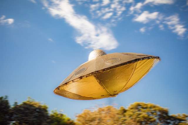 Flying saucer hovering over trees