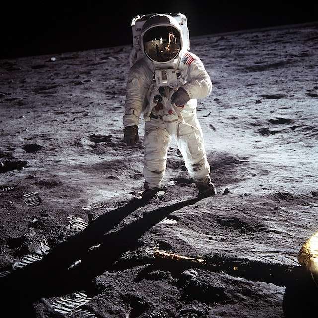 An astronaut stands on the moon