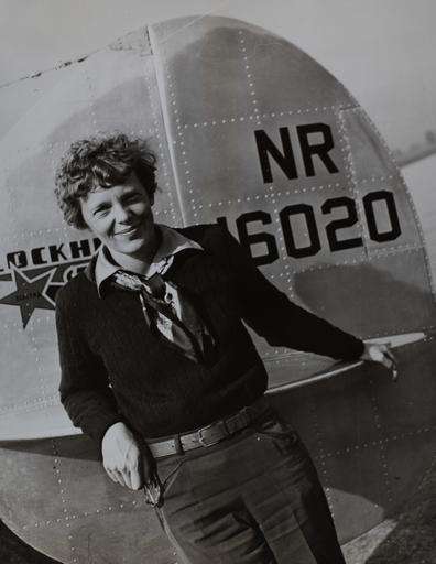 Amelia Earhart poses for a picture in front of her plane