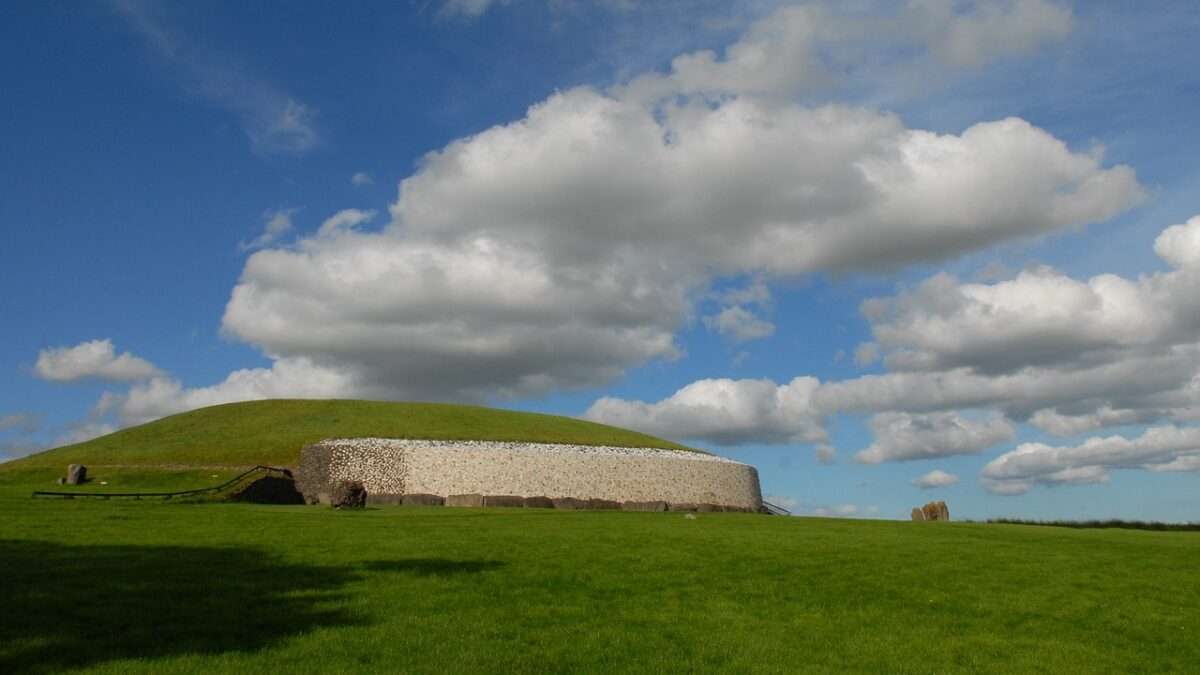 Photo of the newgrange monument at eye level surrounded by clouds