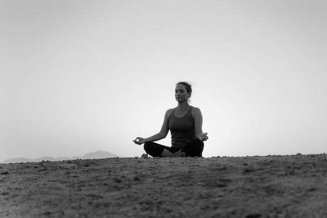 woman meditates in desert