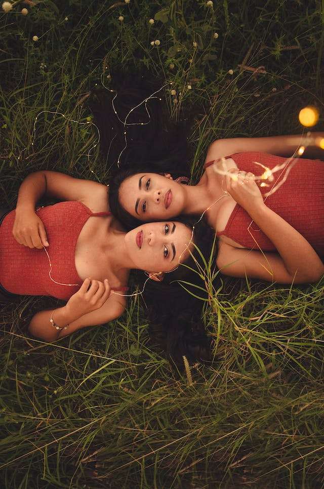 Twins lie in grass