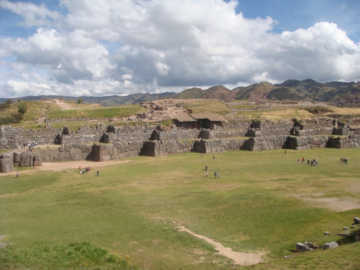 A faraway view of tourists exploring the Sacsayhuaman Fortress