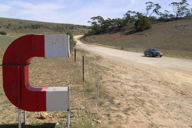 A car drives past a giant magnet